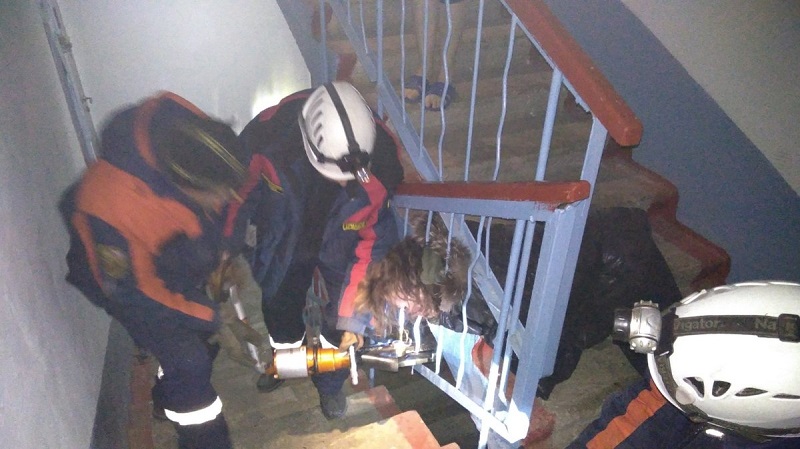 Спасатели вытаскивают женщину, застрявшую в перилах лестницы. Чего она туда полезла?